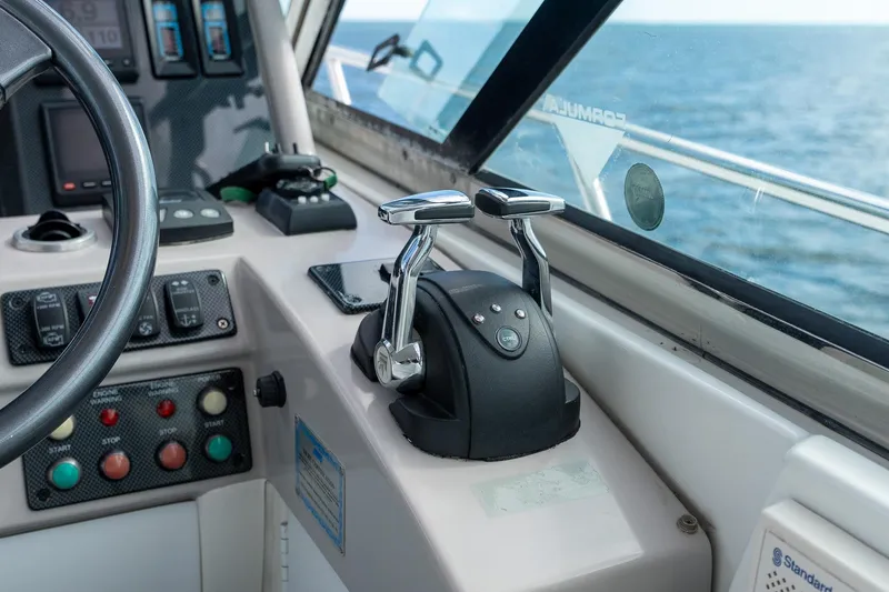 Slide: The Image of Control panel of a 2005 Formula 48 Yacht, featuring throttle levers and navigation instruments. - 23