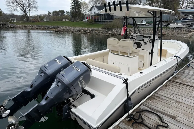 Slide: The Image of 2014 Cobia 256 Center Console boat docked with twin Yamaha 150 engines. - 2