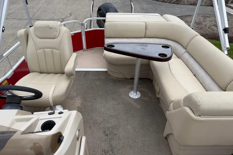 Slide: The Image of 2014 Bennington 21 SLX pontoon boat interior with beige seating and steering console. - 5