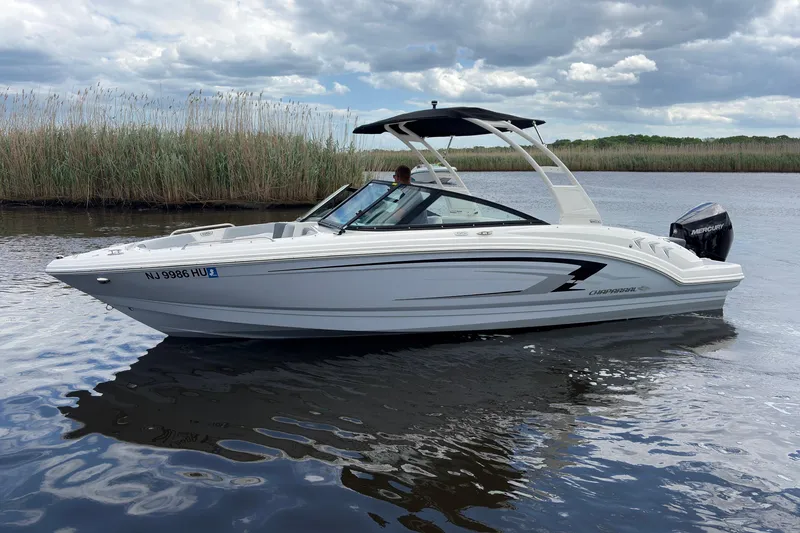 Slide: The Image of 2026 Chaparral 23 SSi OB boat on calm water under cloudy sky. - 1