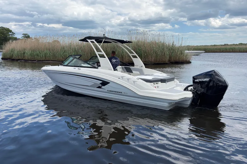 Slide: The Image of 2026 Chaparral 23 SSi OB boat on calm water, featuring sleek design and Mercury outboard engine. - 2