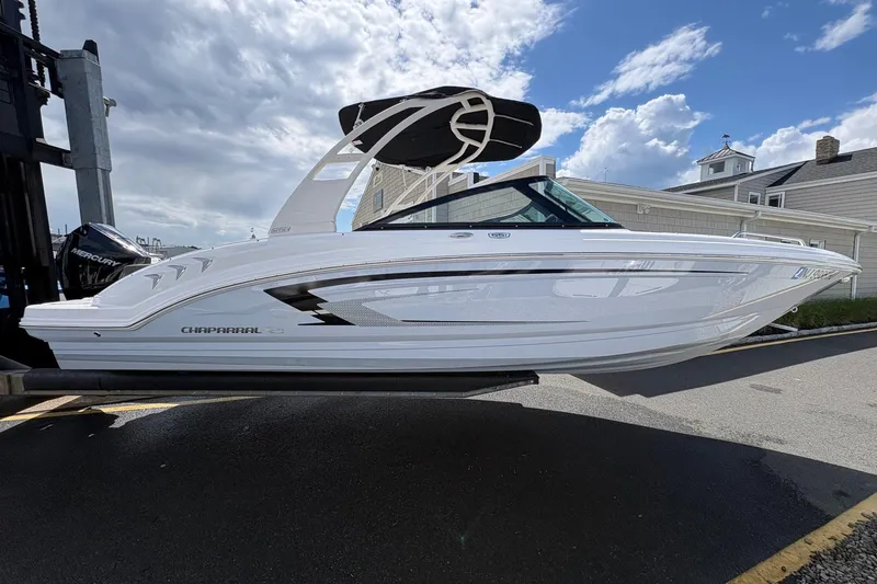 Slide: The Image of 2026 Chaparral 23 SSi OB boat displayed outdoors under a partly cloudy sky. - 20