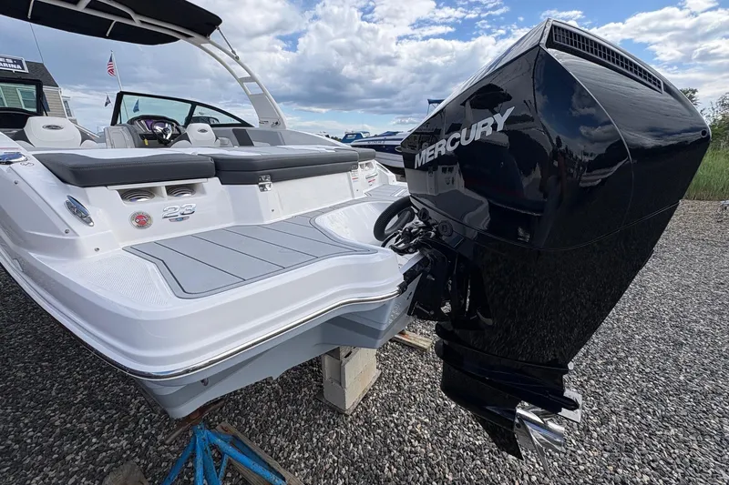 Slide: The Image of 2026 Chaparral 23 SSi OB boat with Mercury outboard engine, docked on gravel. - 25