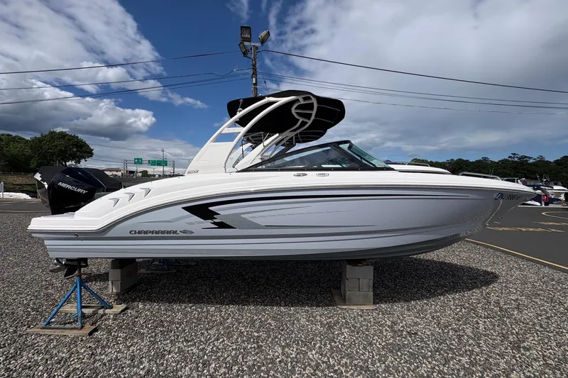 Slide: The Image of 2026 Chaparral 23 SSi OB boat displayed outdoors on a gravel surface. - 28
