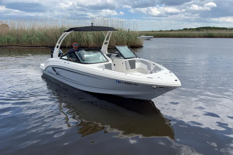 Slide: The Image of 2026 Chaparral 23 SSi OB boat cruising on a calm lake under a cloudy sky. - 5