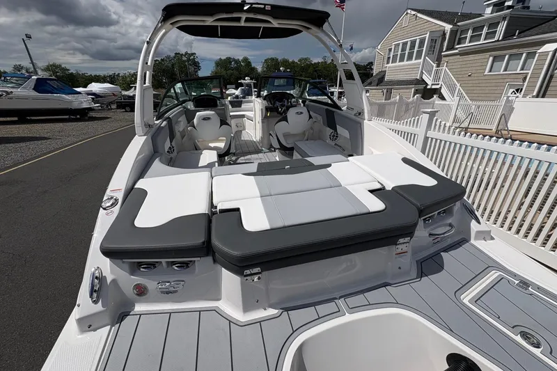 Slide: The Image of 2026 Chaparral 23 SSi OB boat with spacious seating and modern design at a marina. - 7