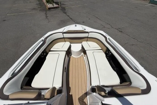 Slide: The Image of 2021 Yamaha Boats 275SD bow seating area with white and tan upholstery. - 10