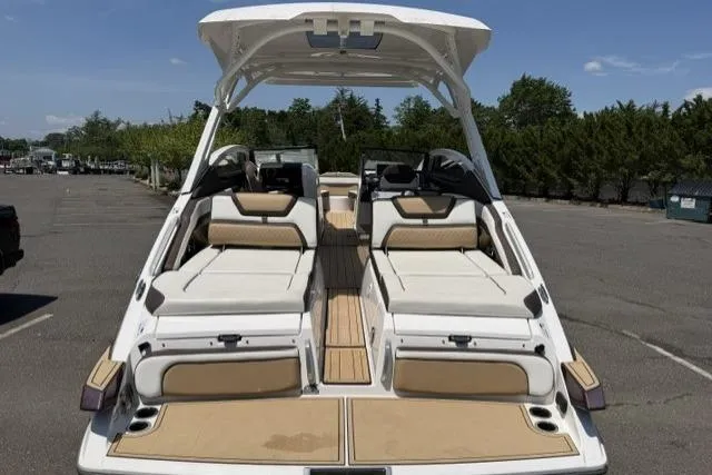 Slide: The Image of 2021 Yamaha Boats 275SD with spacious seating and sleek design in a parking area. - 15