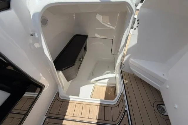 Slide: The Image of 2021 Yamaha Boats 275SD storage compartment with teak flooring and sleek interior design. - 21