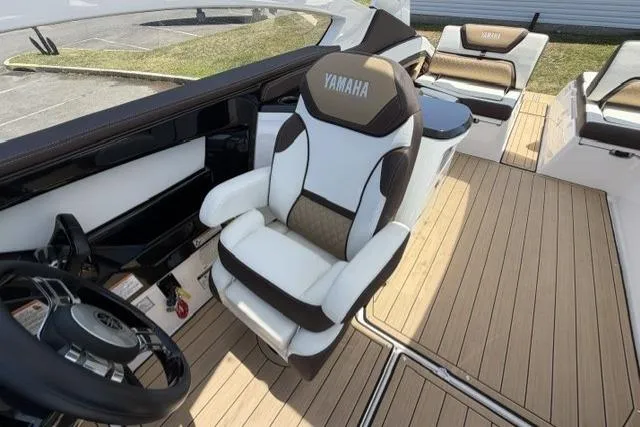 Slide: The Image of 2021 Yamaha Boats 275SD interior with captain's chair and teak flooring. - 28