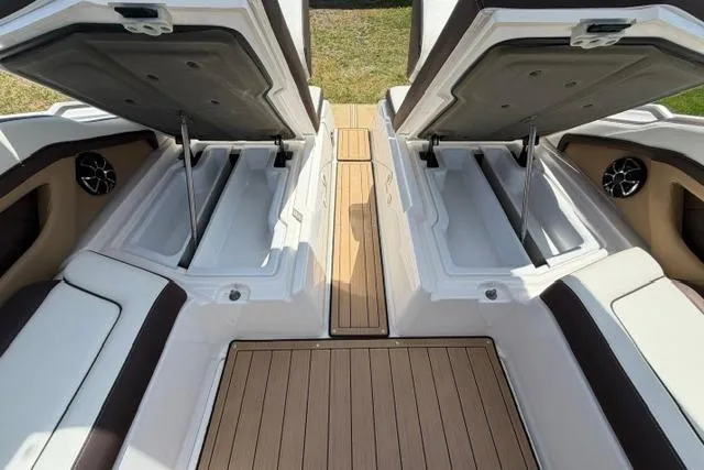 Slide: The Image of 2021 Yamaha Boats 275SD interior storage compartments with open hatches and teak flooring. - 29