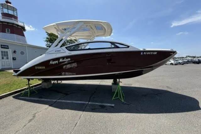 Slide: The Image of 2021 Yamaha Boats 275SD in a parking lot near a lighthouse. - 6