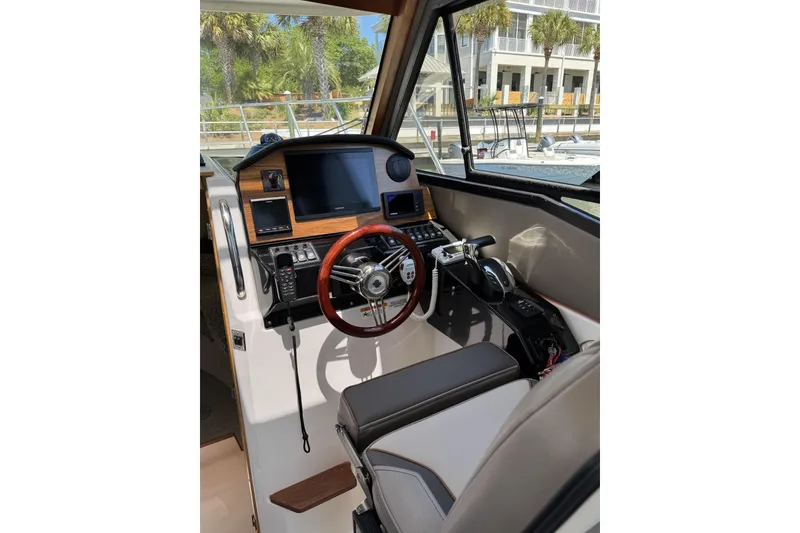Slide: The Image of 2022 Cutwater C-248 Coupe helm with modern controls and wood-accented steering wheel. - 3