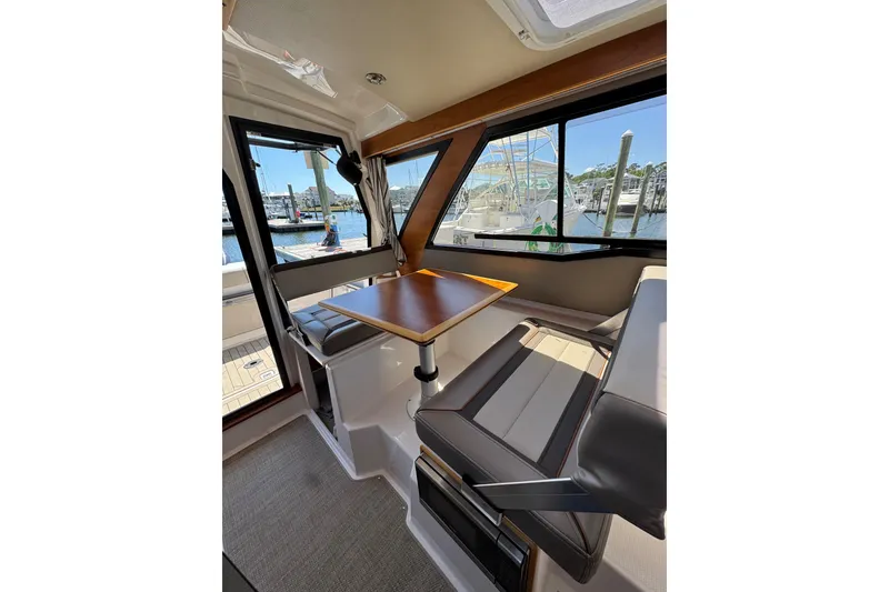 Slide: The Image of Interior of 2022 Cutwater C-248 Coupe boat with seating and table, dock view. - 5