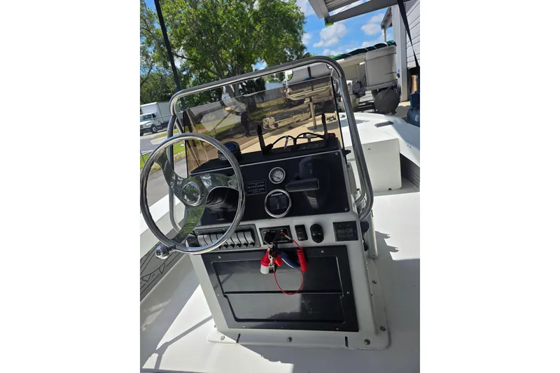 Slide: The Image of 1994 Action Craft Flatsmaster 1810 boat console with steering wheel and controls. - 4