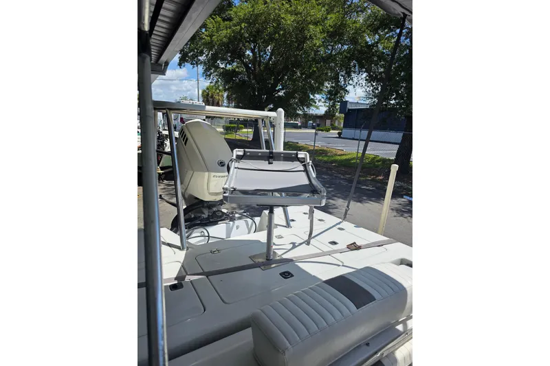 Slide: The Image of 1994 Action Craft Flatsmaster 1810 boat with motor, parked under a canopy. - 7