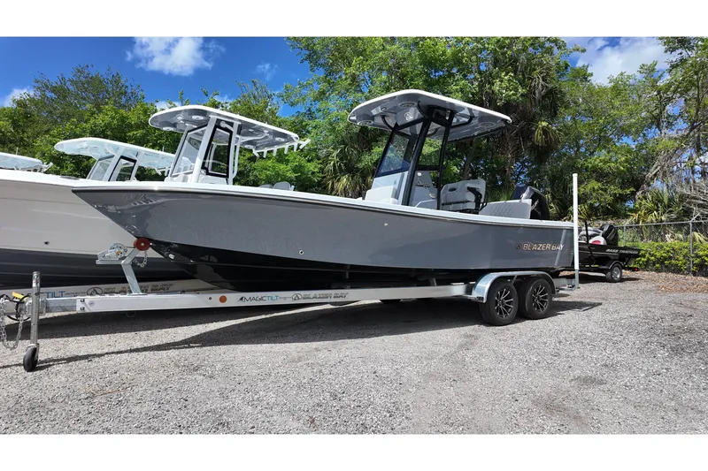 The Image of 2026 Blazer Bay 2440 boat on trailer, parked outdoors with trees in background. - 0