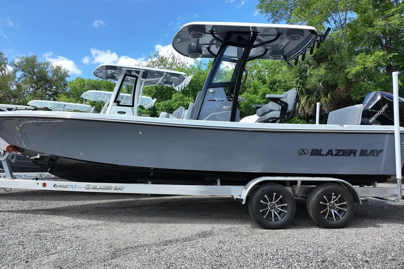 Slide: The Image of 2026 Blazer Bay 2440 boat on trailer, sleek design, parked outdoors. - 2