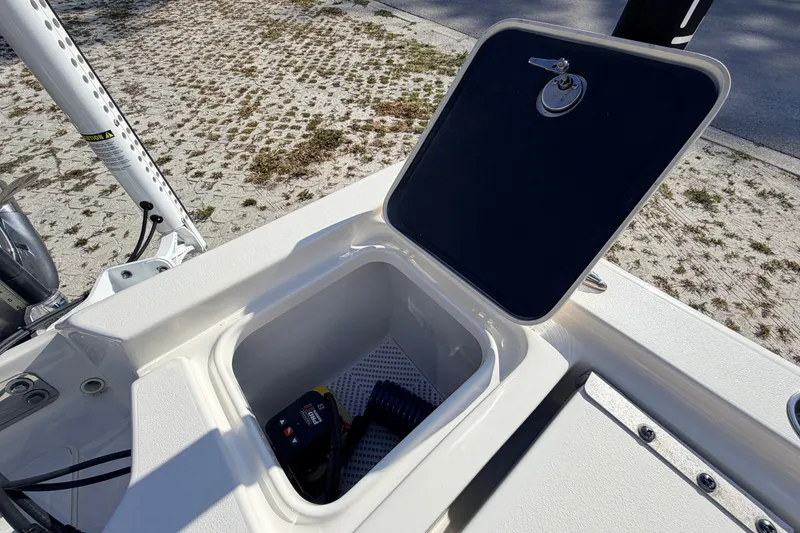 Slide: The Image of 2024 Key West 210 Bay Reef boat storage compartment with open lid and equipment inside. - 105