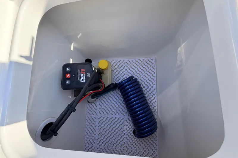 Slide: The Image of Storage compartment of 2024 Key West 210 Bay Reef with coiled hose and control panel. - 106