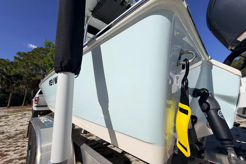 Slide: The Image of 2024 Key West 210 Bay Reef boat on trailer, parked outdoors under clear blue sky. - 20