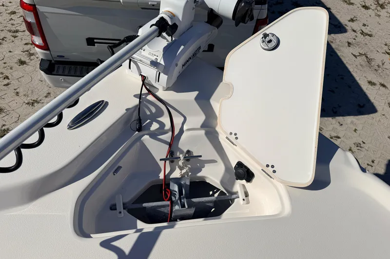 Slide: The Image of 2024 Key West 210 Bay Reef boat anchor compartment with open hatch and trolling motor. - 32