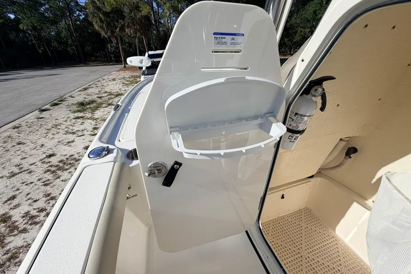 Slide: The Image of 2024 Key West 210 Bay Reef boat interior with storage compartment and fire extinguisher. - 57