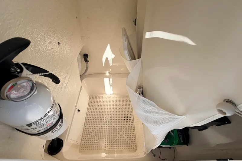 Slide: The Image of Interior of 2024 Key West 210 Bay Reef boat with fire extinguisher and storage area. - 59