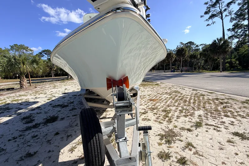 Slide: The Image of 2024 Key West 210 Bay Reef boat on trailer, parked outdoors under clear blue sky. - 7