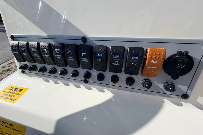Slide: The Image of Control panel of 2024 Key West 210 Bay Reef boat with labeled switches and horn. - 72