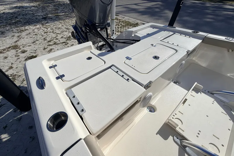 Slide: The Image of 2024 Key West 210 Bay Reef boat deck with storage compartments and motor. - 93