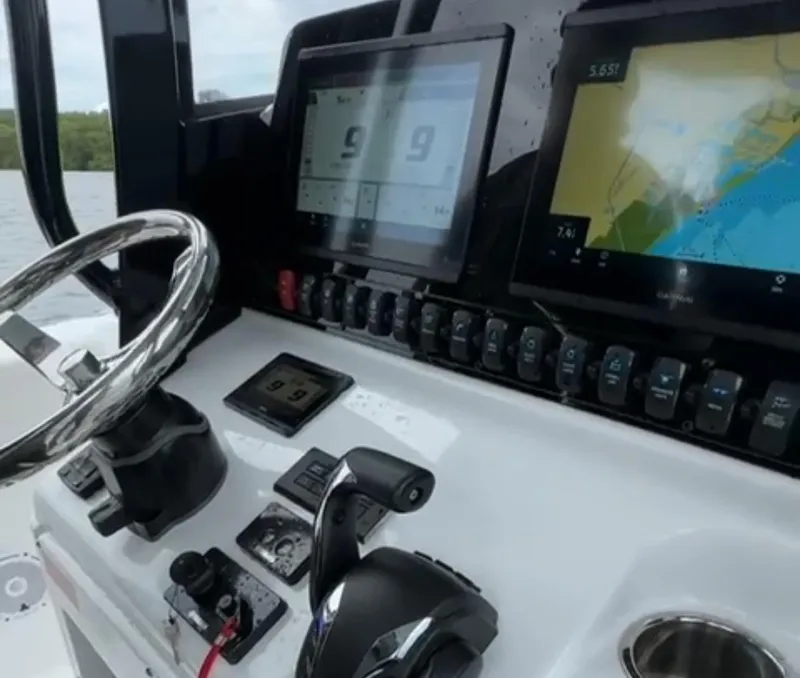 Slide: The Image of Control panel of 2023 Sea Hunt Gamefish 27 boat with navigation screens and steering wheel. - 11