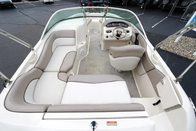 Slide: The Image of 2002 Sea Ray 190 Sundeck interior with beige seating and steering console. - 8