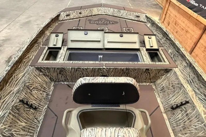Slide: The Image of 2026 Tracker Grizzly 2072 CC boat interior with camouflage design and storage compartments. - 2