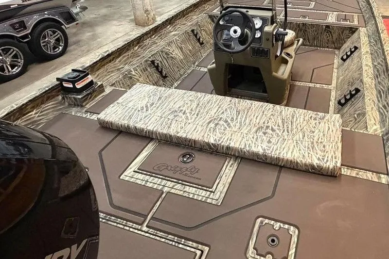 Slide: The Image of 2026 Tracker Grizzly 2072 CC boat interior with camouflage design and steering console. - 4
