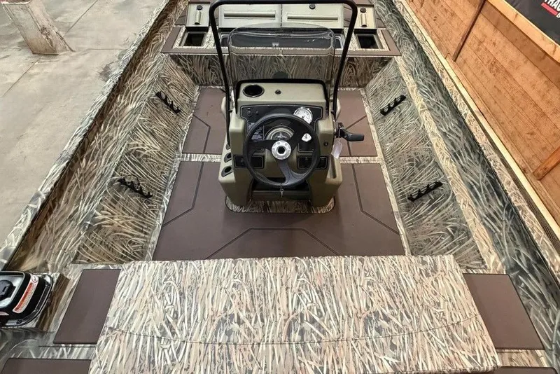 Slide: The Image of 2026 Tracker Grizzly 2072 CC boat interior with camouflage design and central steering console. - 6