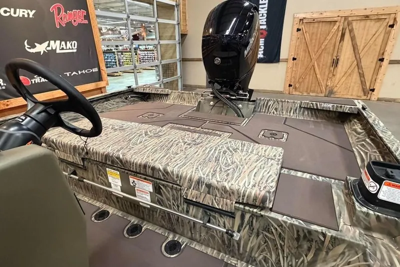 Slide: The Image of 2026 Tracker Grizzly 2072 CC boat with camo design and Mercury engine in showroom. - 9