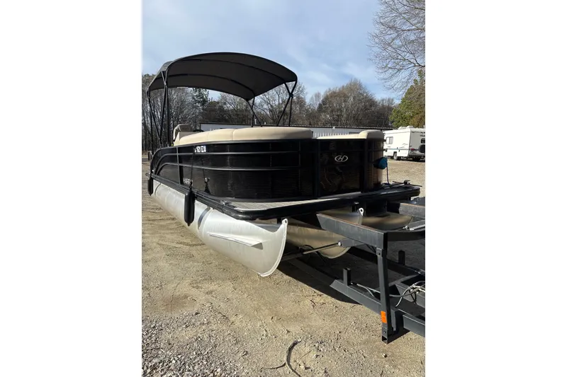 Slide: The Image of 2023 Harris Cruiser 230 pontoon boat on trailer, parked outdoors. - 10