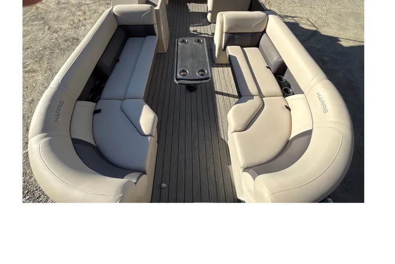 Slide: The Image of 2023 Harris Cruiser 230 boat interior with beige seating and central table. - 12