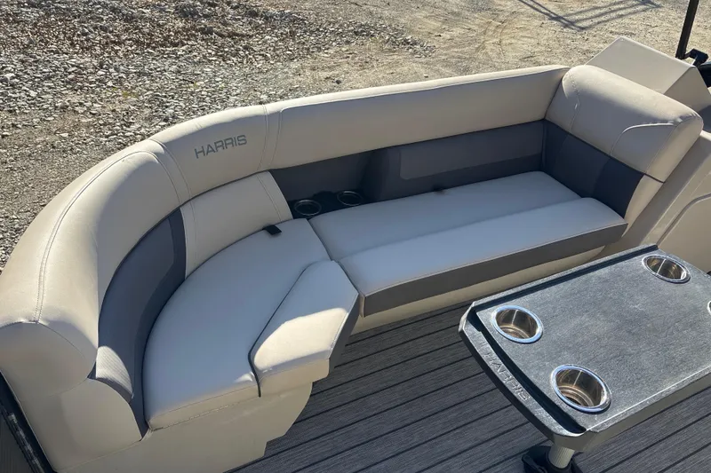 Slide: The Image of 2023 Harris Cruiser 230 boat interior with cushioned seating and table with cup holders. - 13