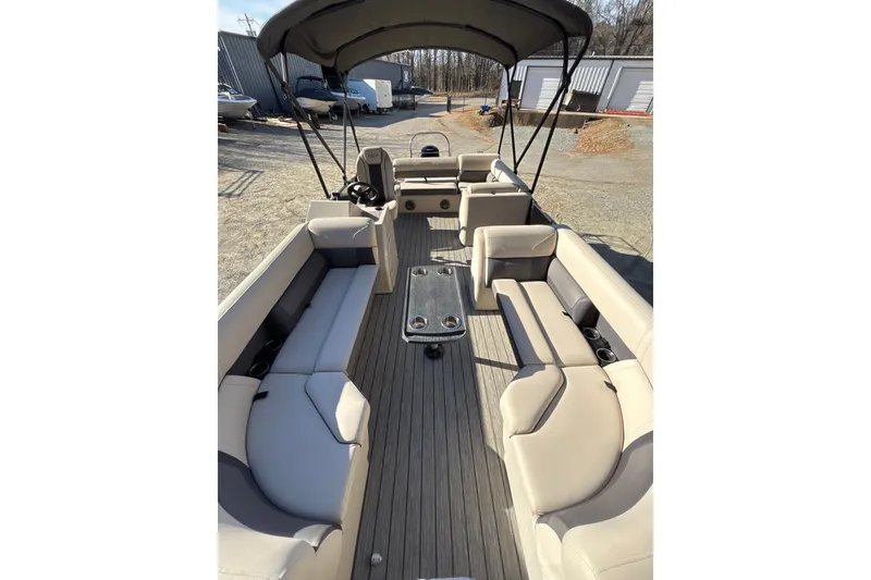 Slide: The Image of 2023 Harris Cruiser 230 pontoon boat with spacious seating and canopy, docked outdoors. - 15