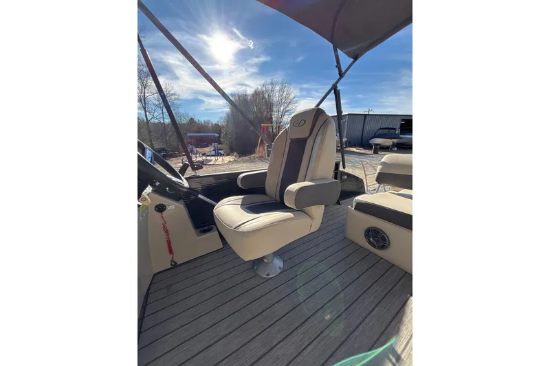 Slide: The Image of 2023 Harris Cruiser 230 boat interior with captain's chair under sunny sky. - 20