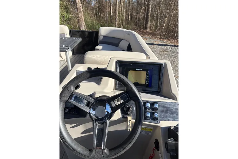 Slide: The Image of 2023 Harris Cruiser 230 boat dashboard with steering wheel and navigation display. - 21