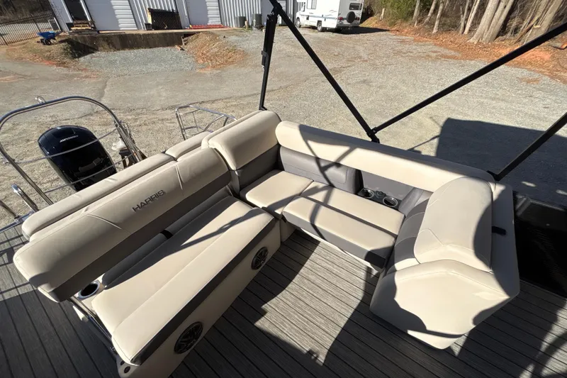 Slide: The Image of 2023 Harris Cruiser 230 boat interior with beige seating and cup holders. - 22
