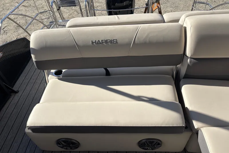 Slide: The Image of 2023 Harris Cruiser 230 boat seating with beige upholstery and integrated speakers. - 23