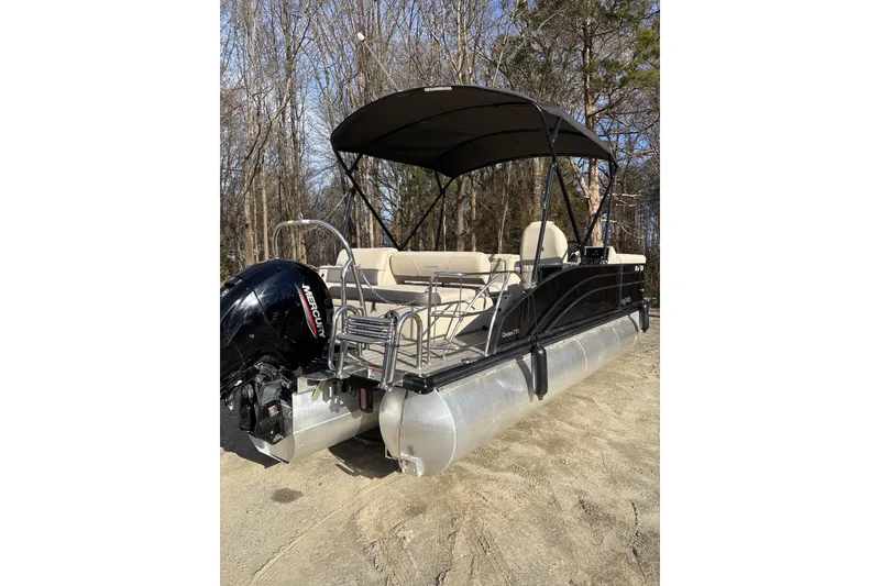 Slide: The Image of 2023 Harris Cruiser 230 pontoon boat with canopy, parked on sandy ground. - 7