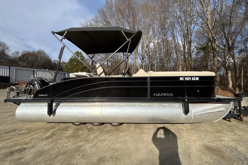 Slide: The Image of 2023 Harris Cruiser 230 pontoon boat with canopy, parked on a trailer. - 8