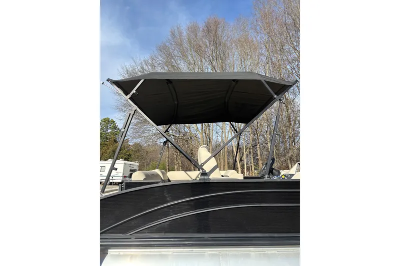Slide: The Image of 2023 Harris Cruiser 230 pontoon boat with canopy, parked outdoors. - 9