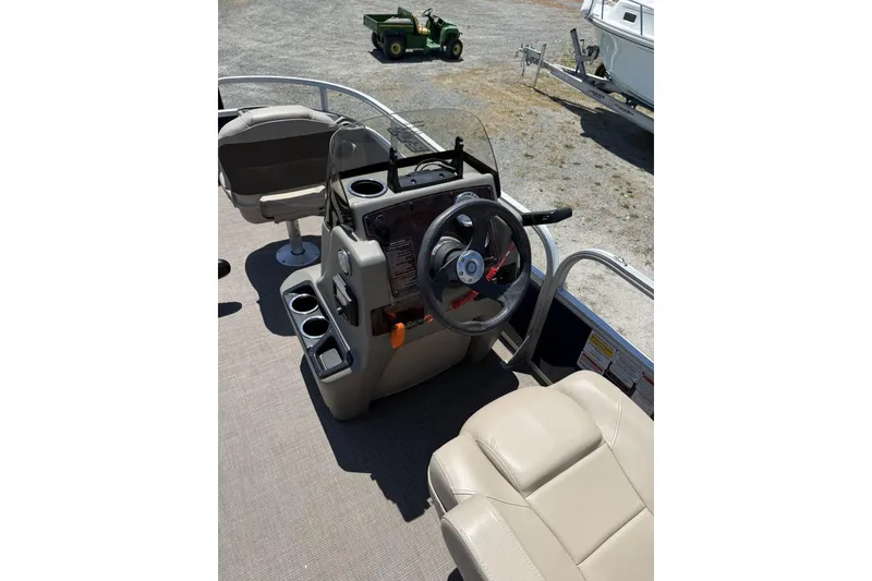 Slide: The Image of 2024 Sun Tracker Bass Buggy 18 DLX pontoon boat interior with steering console and seating. - 4