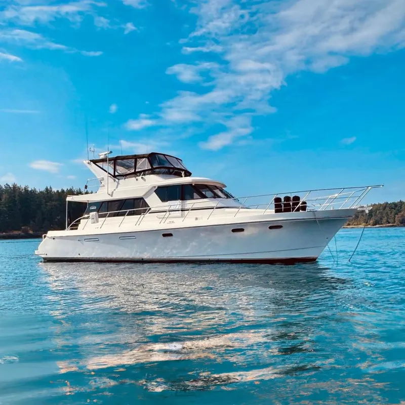 The Image of A 1995 Symbol Pilothouse yacht on calm water under a clear blue sky. - 0